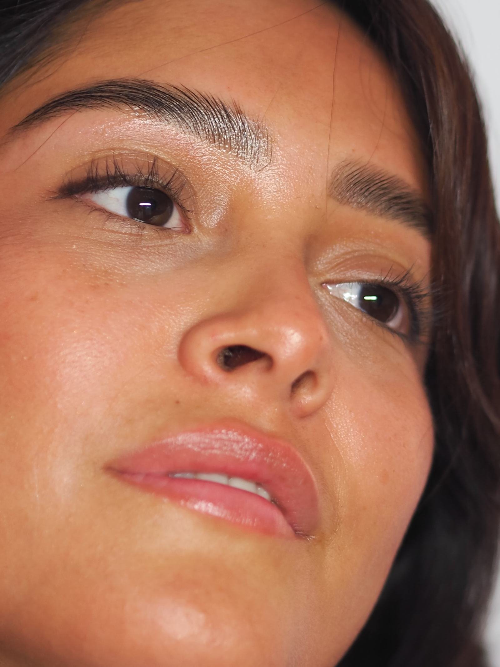 Gros plan d’un visage, peau et sourcil en lumière naturelle